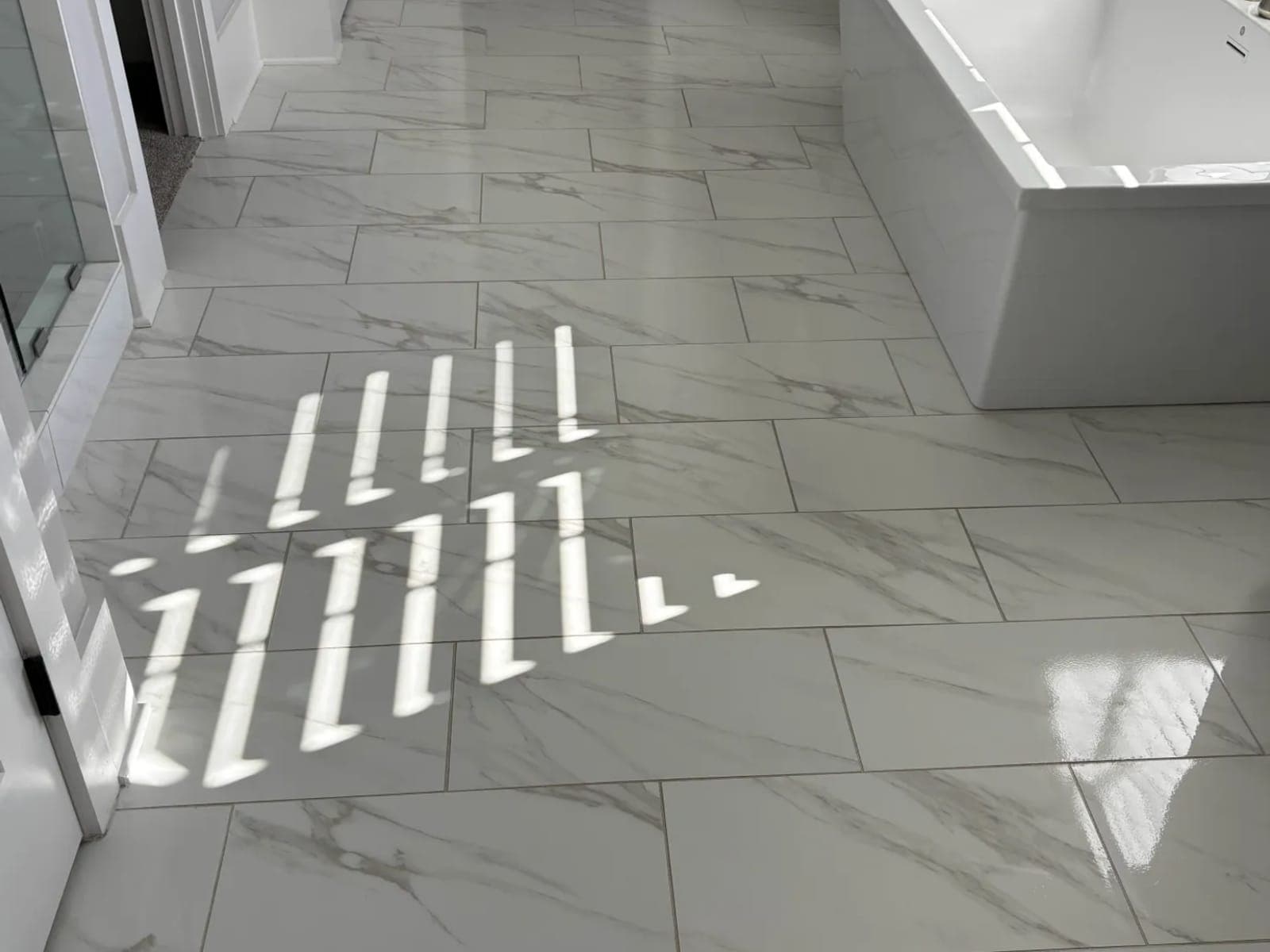 Bathroom tile floor around a freestanding tub, dry and streak-free