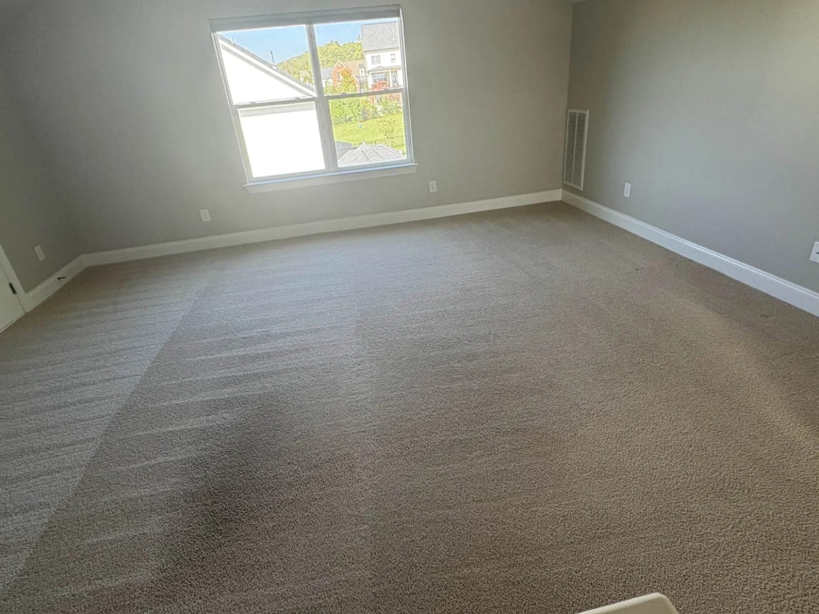Empty bedroom with the carpet dried and groomed after service
