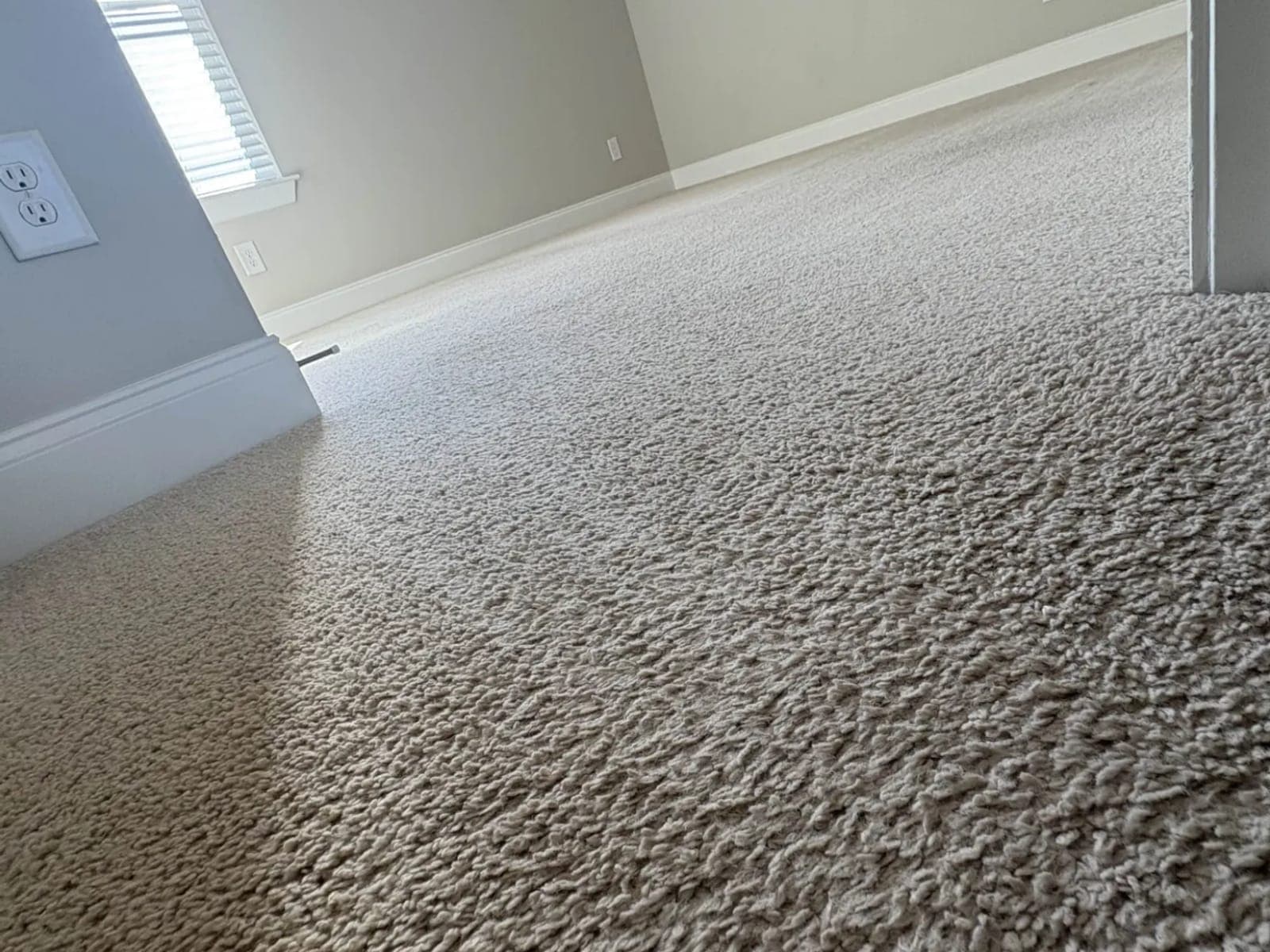 Floor-level view across carpet pile toward the next room