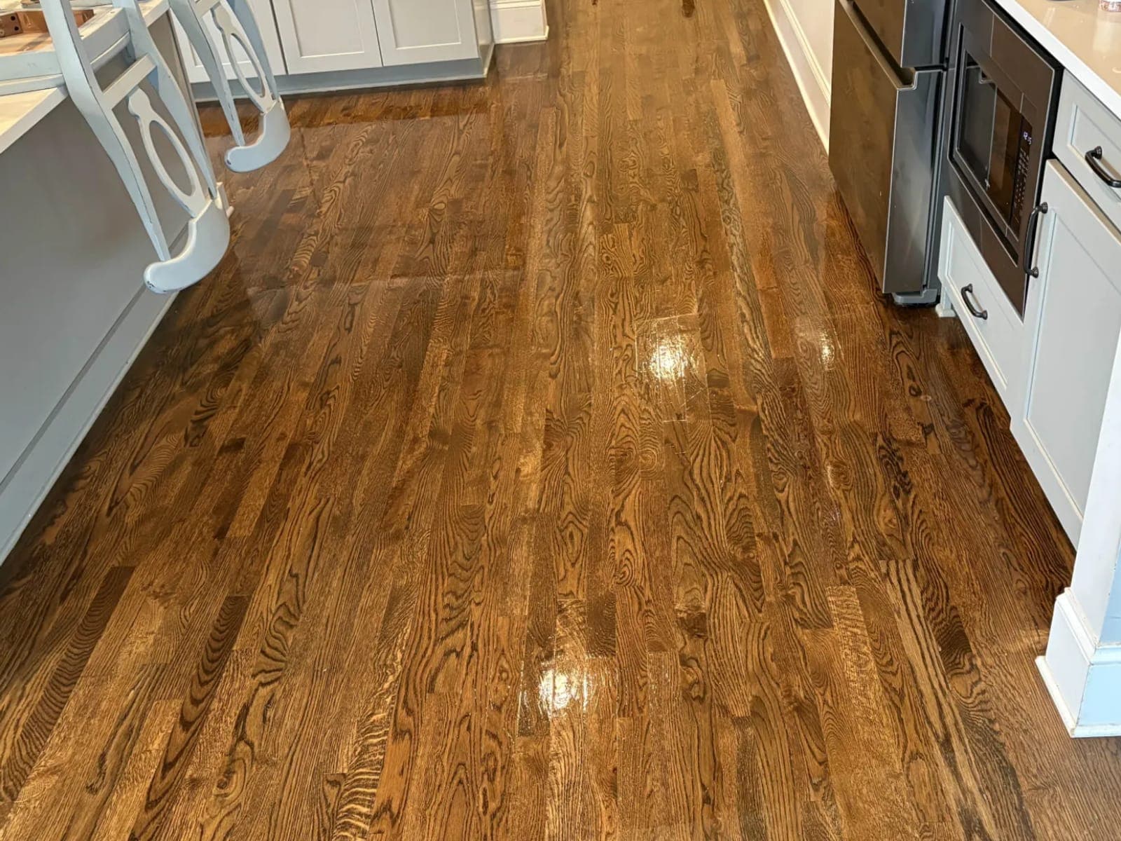 Kitchen hardwood floor dried and cleaned along the cabinet run
