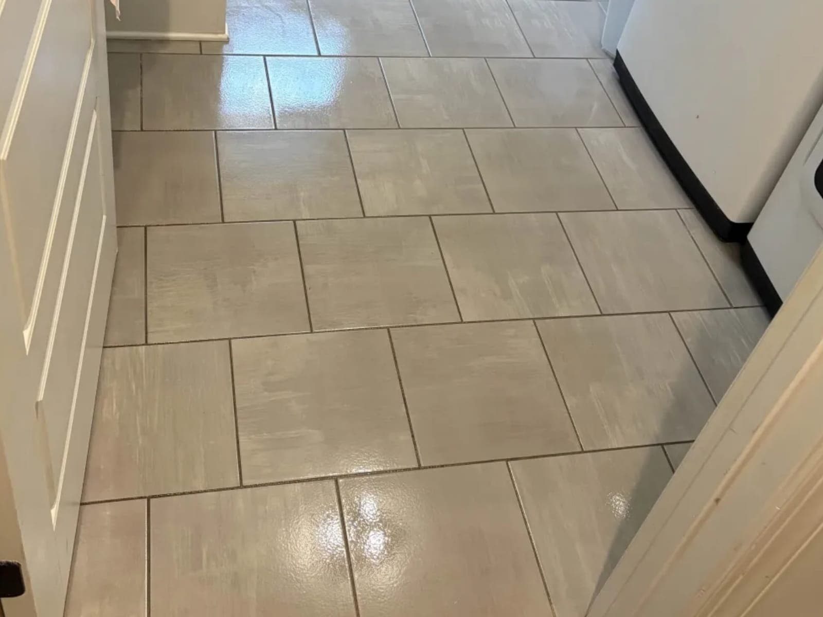 Laundry room tile floor between the washer and the cabinets
