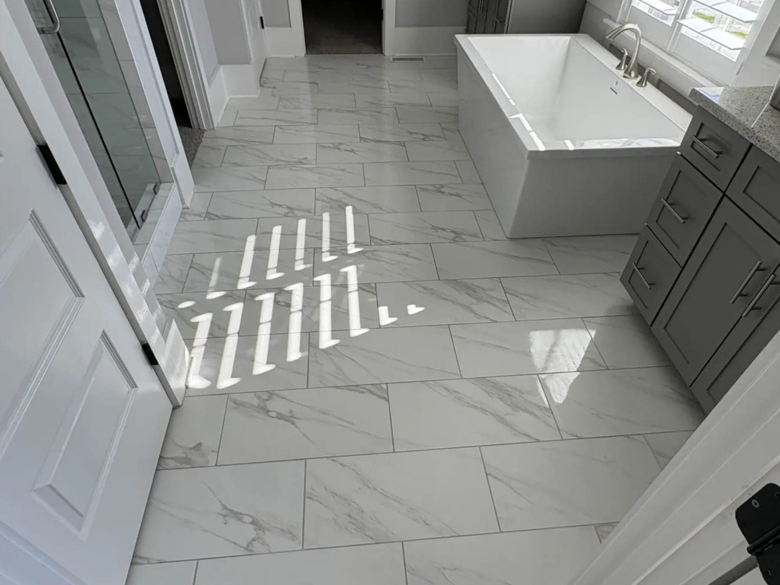Marble-look tile floor running through a bathroom, cleaned and dried